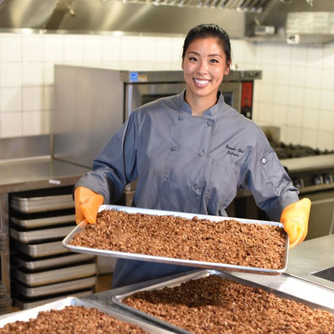 Erica Liu Williams founder of Gr8nola displaying a recent batch of granola cooked in a Gr8nola Kitchen